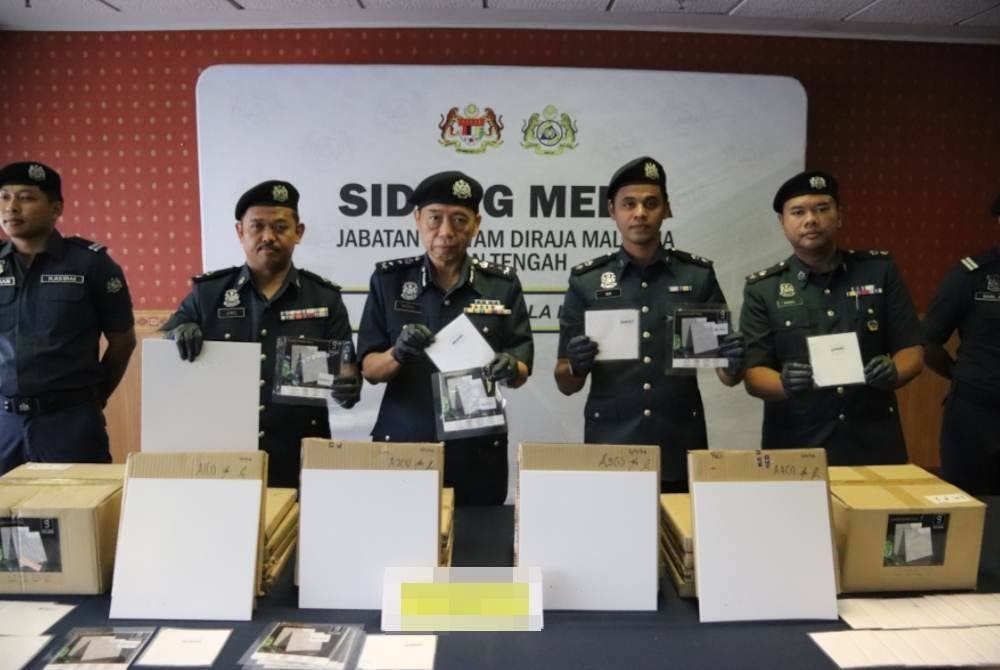 Pun Sian (tengah) menunjukkan kotak kecil berisi dadah yang dirampas kastam di sebuah premis di Nilai, Negeri Sembilan pada 6 November lalu..