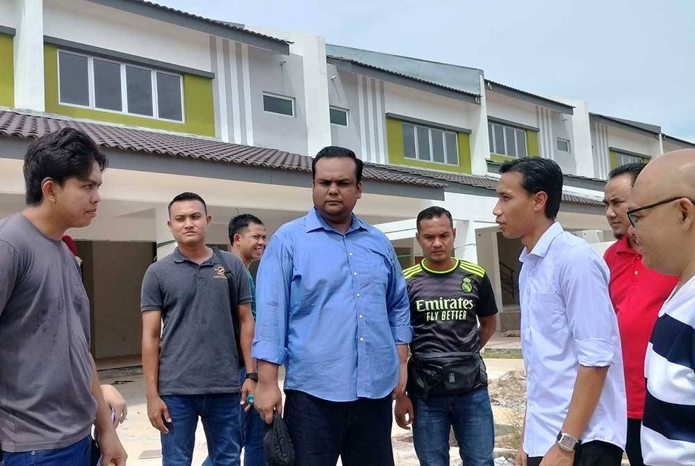 Baddrol (dua dari kanan) bersama pembeli rumah Taman Residensi Mesra Gurun Fasa 1 melihat keadaan rumah mereka pada Jumaat.