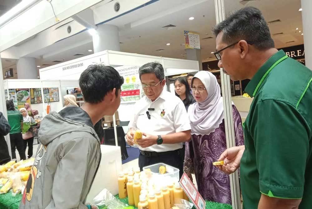 Jalaluddin (kiri) ketika melawat setiap gerai di Karnival Usahawan Asas Tani dan myGAP pada Jumaat.