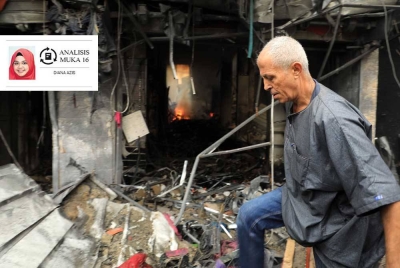 Seorang lelaki berjalan melalui bangunan yang musnah dibedil tentera Israel di Gaza. - Foto Xinhua