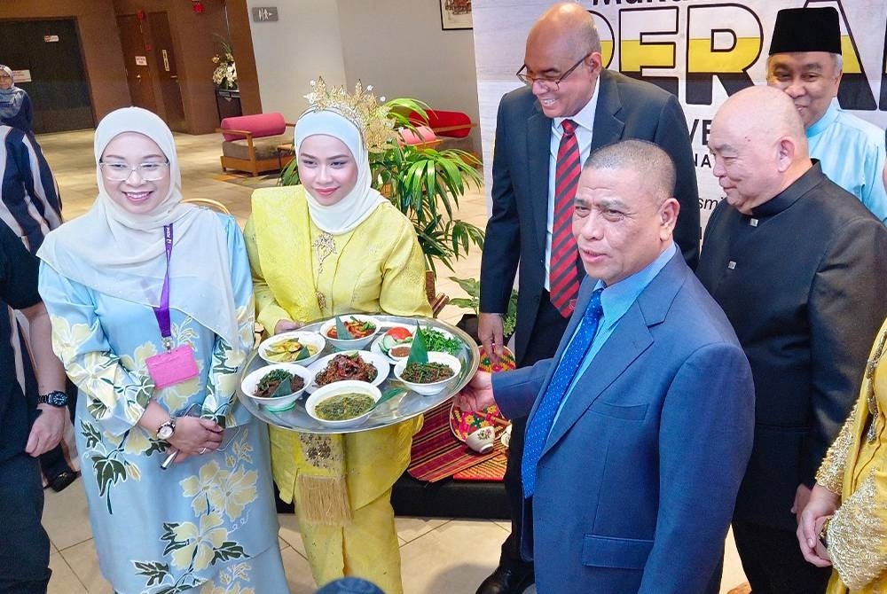 Saarani (kanan) melihat set talam yang mengandungi pelbagai makanan tradisi Perak yang diperkenalkan buat pengunjung sempena TMP 2024