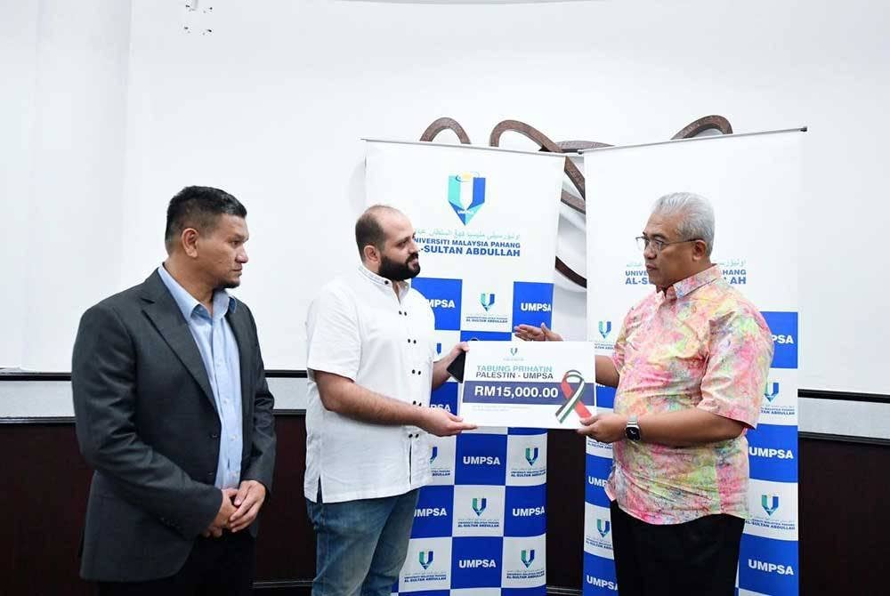 Dr Yuserrie menyerahkan sumbangan kepada Yasin Y Albarqouni dalam satu majlis di UMPSA Kampus Pekan pada Jumaat.