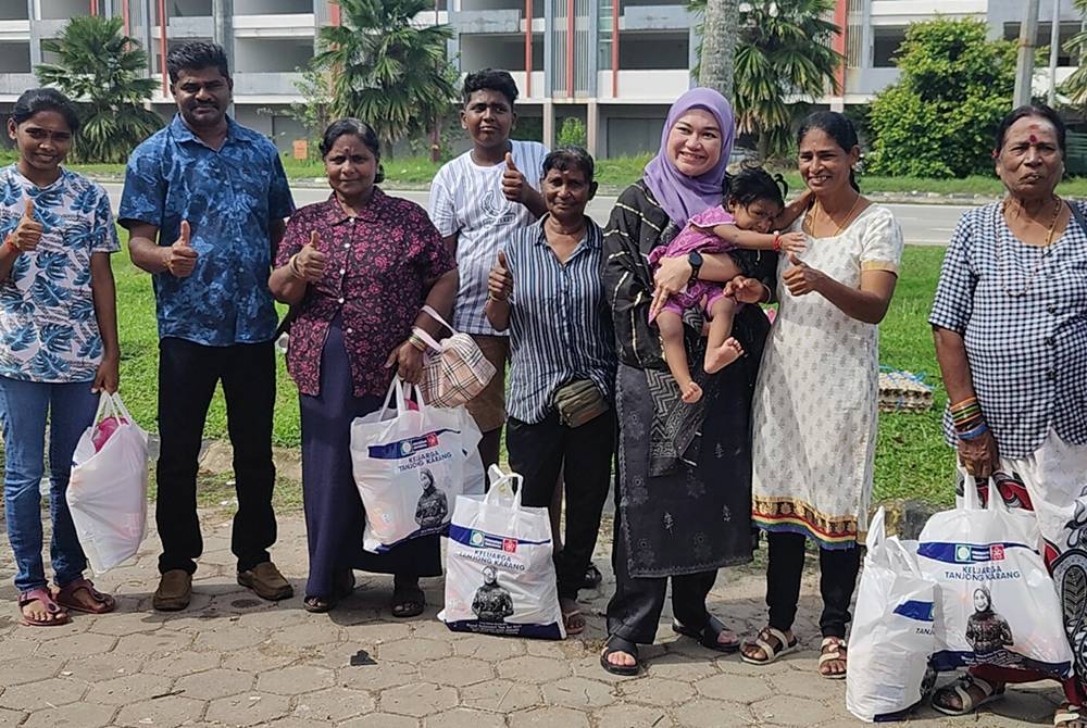 Nurul Syazwani (tiga dari kanan) bergambar bersama-sama sebahagian penerima sumbangan pada program berkenaan.