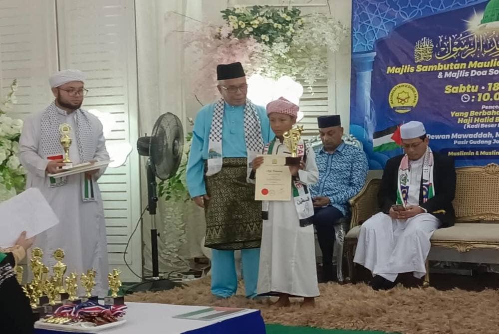 Hassan menyampaikan sijil dan piala kepada pemenang dalam Majlis Sambutan Maulidur Rasul 1445/2023M dan Majlis Doa Solidariti Palestin di Dewan Mawaddah Masjid Bandar Seri Alam, Pasir Gudang pada Sabtu