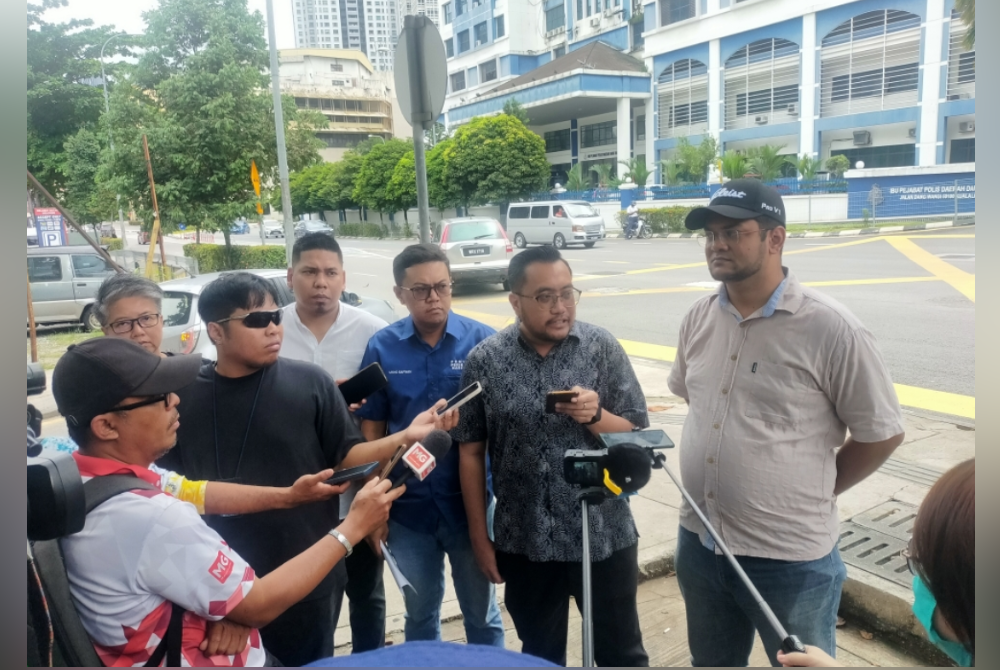 Muhammad Faiz (dua dari kanan) menjawab soalan daripada pihak media selepas membuat laporan polis berhubung video yang dikaitkan dengan Mohammad Agus di IPD Dang Wangi, Kuala Lumpur pada Sabtu.