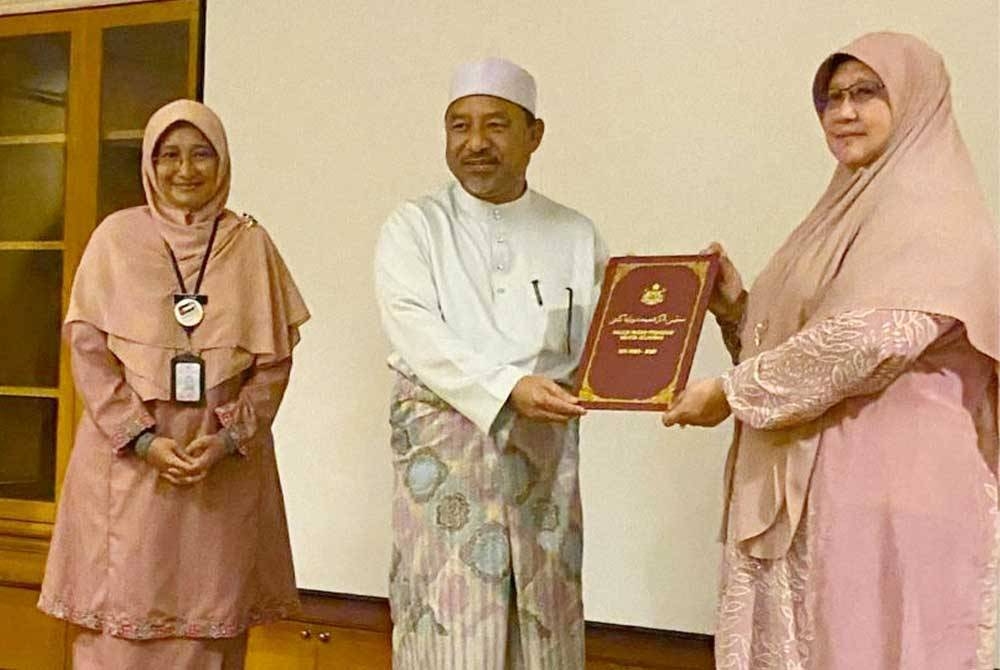 Rohani (kanan) menyampaikan cenderamata kepada Mohd Nassuruddin yang hadir merasmikan Majlis Penyerahan Watikah Pelantikan Ahli Majlis Pakar Penasihat Wanita Kelantan 2023-2027 di Kota Bharu pada Ahad.