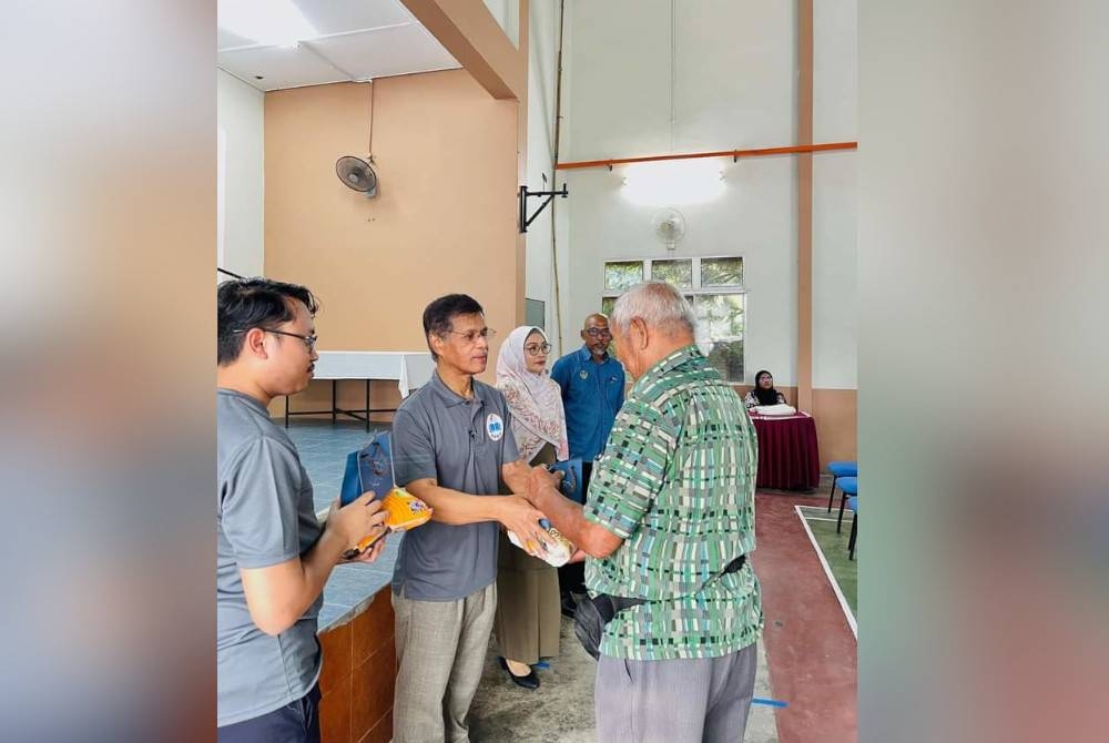 Zahar (dua dari kiri) turut menyampaikan sumbangan kepada penerima sempena Program CSR DPMP di Dewan Serbaguna Padang Tembak, Teluk Muroh pada Sabtu.