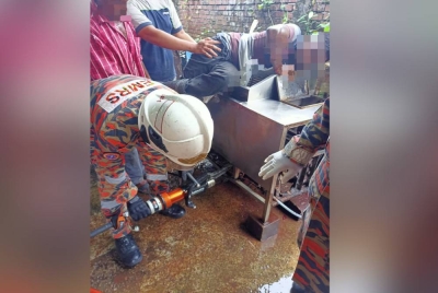 Anggota bomba menggunakan peralatan khas mengeluarkan tangan seorang lelaki yang tersepit dalam mesin memproses ayam.
