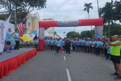 Ken Jin (kiri) membuat pelepasan acara larian 'Miles with ecoBrown's' yang diadakan Esplanade, Padang Kota Lama pada Ahad.