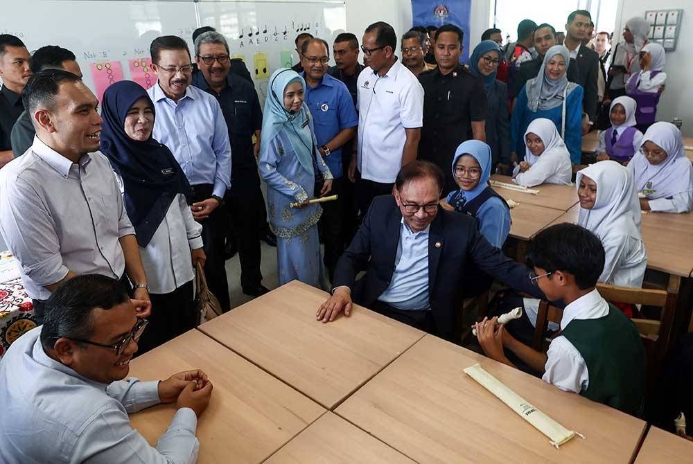 Anwar beramah mesra bersama murid sekolah pada majlis penyerahan dan perasmian Projek Rintis Bangunan Daif di Sekolah Kebangsaan Bandar Baru Bangi - Foto Bernama