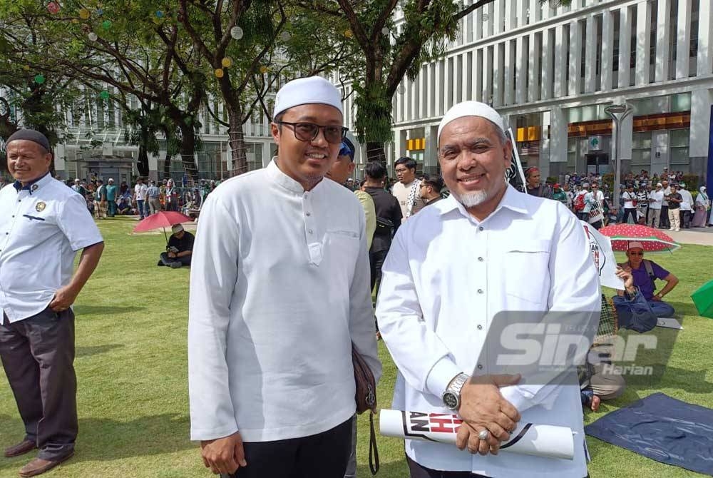 Kamarol Ridzuan (kiri) mengenakan pakaian putih dalam Himpunan Selamatkan Syariah yang diadakan di pekarangan Istana Kehakiman pada Isnin.