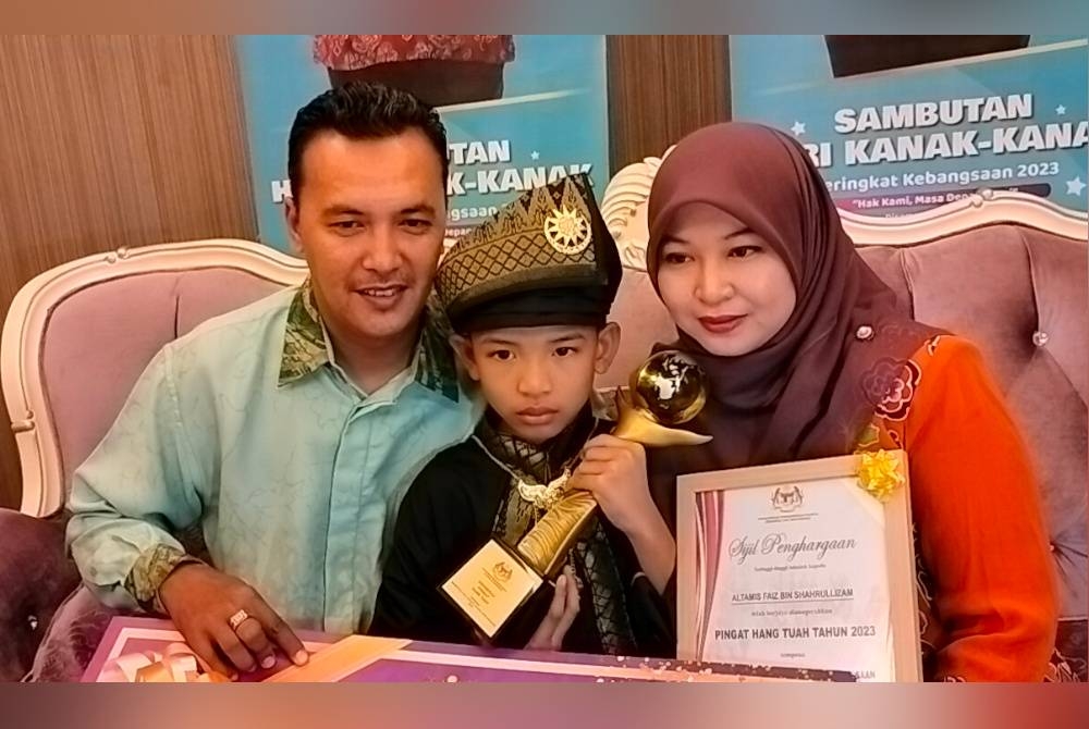 Altamis Faiz (tengah) bergambar bersama ibu dan bapanya selepas menerima pingat Hang Tuah sempena sambutan Hari Kanak-Kanak Peringkat Kebangsaan 2023 di Johor Bahru pada Isnin.