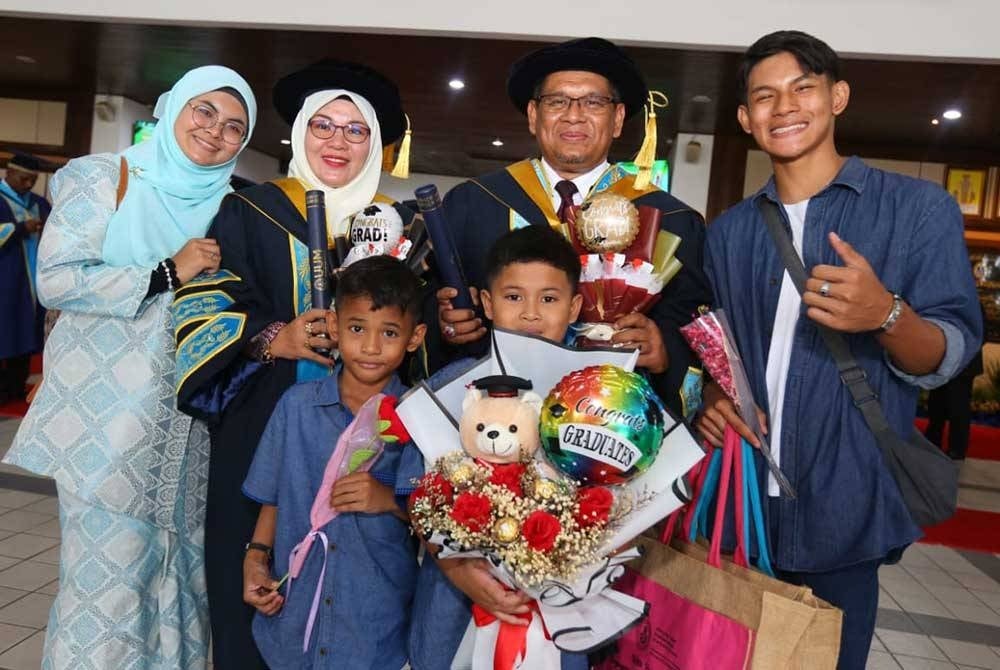 Mohd Akhmarudi dan Musliza bersama keluarga mereka selepas sesi kedua Majlis Konvokesyen Ke-36 UUM yang berlangsung di Dewan Mu'adzam Shah, di Sintok pada Isnin.