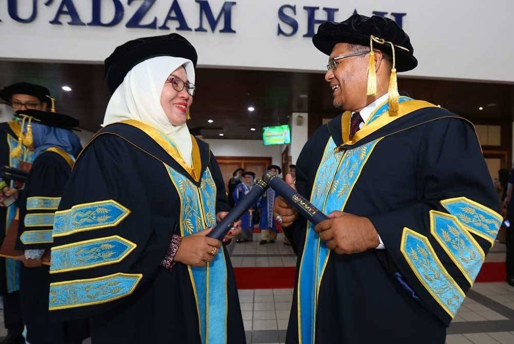 Mohd Akhmarudi (kanan) dan Musliza meraikan kejayaan mereka pada sesi kedua Majlis Konvokesyen Ke-36 UUM yang berlangsung di Dewan Mu'adzam Shah, di Sintok pada Isnin.