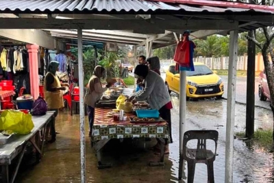 Peniaga tetap menjual sarapan kepada pelanggan walaupun air melimpah ke dalam kedai.