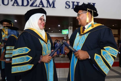 Mohd Akhmarudi (kanan) dan Musliza meraikan kejayaan mereka pada sesi kedua Majlis Konvokesyen Ke-36 UUM yang berlangsung di Dewan Mu'adzam Shah, di Sintok pada Isnin.