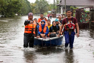 Penduduk terlibat banjir dibantu anggota Angkatan Pertahanan Awam Malaysia (APM) pindah ke PPS semasa tinjauan di Kampung Gelong Gajah, Pasir Panjang, pada Isnin. - Foto Bernama