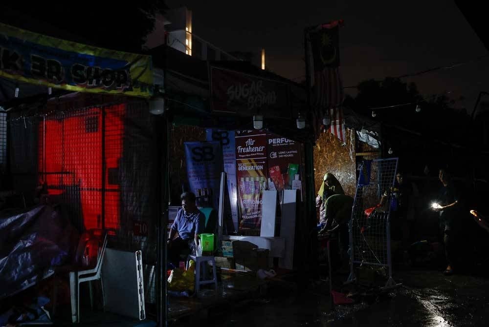 Peniaga-peniaga mengalihkan barangan yang musnah dalam kejadian kebakaran di Uptown Damansara kira-kira jam 8 malam tadi. - Foto Bernama