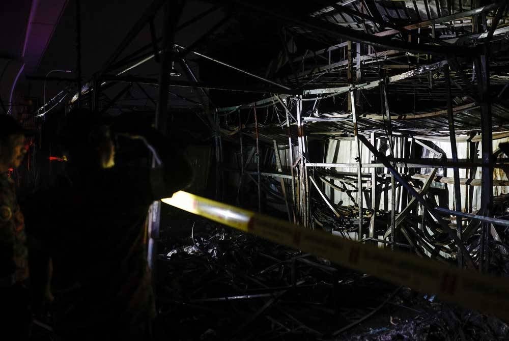 Anggota Jabatan Bomba dan Penyelamat Malaysia memeriksa keadaan deretan kawasan gerai-gerai peniaga yang terbakar 90 peratus dalam kejadian kebakaran di Uptown Damansara kira-kira jam 8 malam tadi. - Foto Bernama