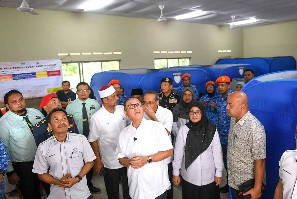 Wan Rosdy (depan; dua dari kiri) meninjau kemudahan elektrik yang dipasang Pusat Pemindahan Tetap (PTT) Kampung Luit pada majlis perasmian PPT yang merupakan PTT pertama di Malaysia hari ini. - Foto Bernama