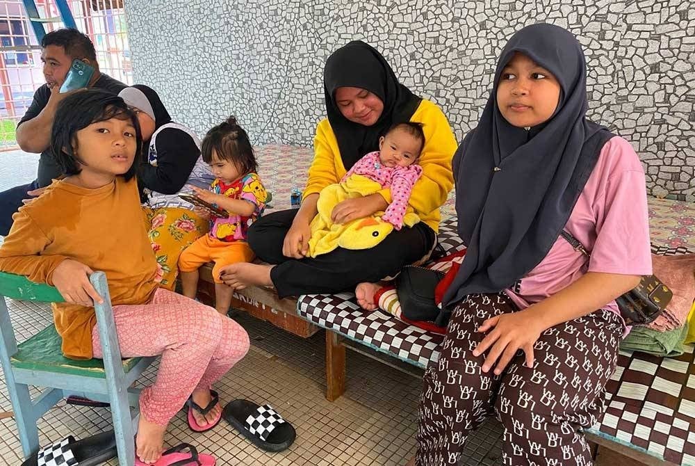 Nur Atia Natasha (dua,kanan) bersama lima lagi adik-beradiknya yang berusia 15 hingga dua bulan terpaksa berpindah awal kerana air telah melimpah ke dalam rumah.