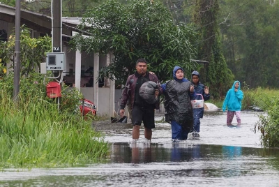 Penduduk Kampung Alor Surau Panjang membawa barangan untuk ke tempat lebih selamat selepas rumah mereka dilimpahi air berikutan hujan lebat sejak beberapa hari lepas. - Foto Bernama