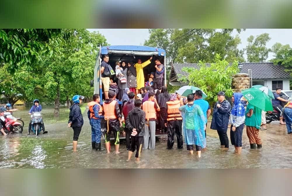 Mangsa banjir dipindahkan ke PPS oleh anggota penyelamat.