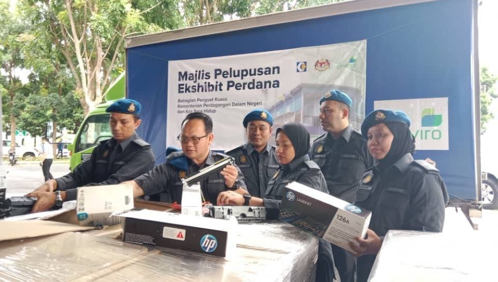 Anggota penguat kuasa KPDN memeriksa barang yang akan di lupuskan.