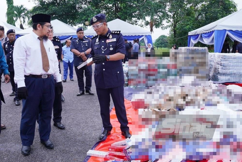 Ketua Polis Daerah Kajang, Asisten Komisioner Mohd Zaid Hassan (kanan) menunjukkan barangan kes kepada Effandi Nazila (dua dari kiri) semasa majlis pelupusan barang kes dan lelongan kenderaan, Ibu Pejabat Polis Daerah Kajang Tahun 2023 di pekarangan Balai Polis Bandar Baru Bangi pada Rabu. - Foto Sinar Harian MOHD HALIM ABDUL WAHID