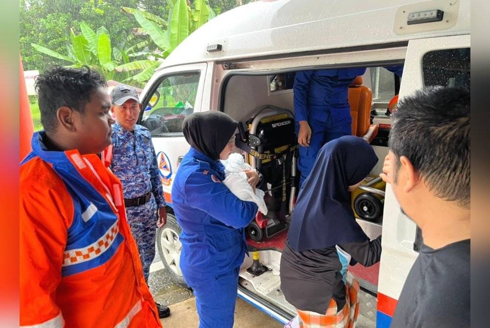 Anggota APM membawa bayi berusia empat hari bersama ibunya menaiki ambulans untuk menerima rawatan.