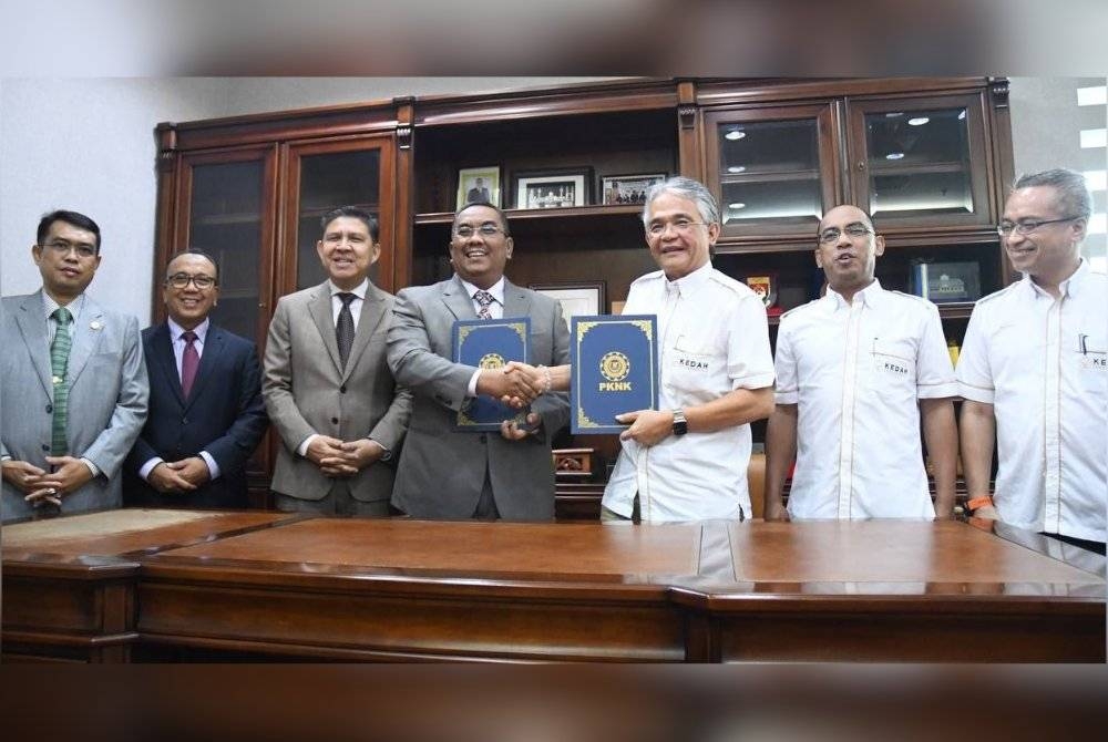 Muhammad Sanusi (empat, kiri) bertukar dokumen dengan Vincent (tiga, kanan) selepas menandatangani perjanjian penubuhan SPV antara PKNK dengan Tahira Air Sdn Bhd bagi membangunkan Kedah Aerotropolis.