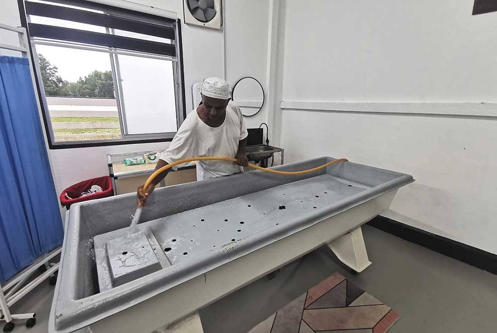 Shahmil Hameed membersihkan tempat mendi jenazah atau palong ketika ditemui pemberita di kediamannya di Kampung Pasir Panjang, Kuala Terengganu.