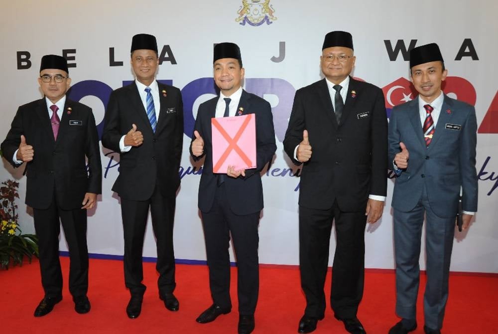 Onn Hafiz (tengah) menunjukkan fail Belanjawan Johor 2024 di Bangunan Sultan Ismail, Kota Iskandar pada Khamis.