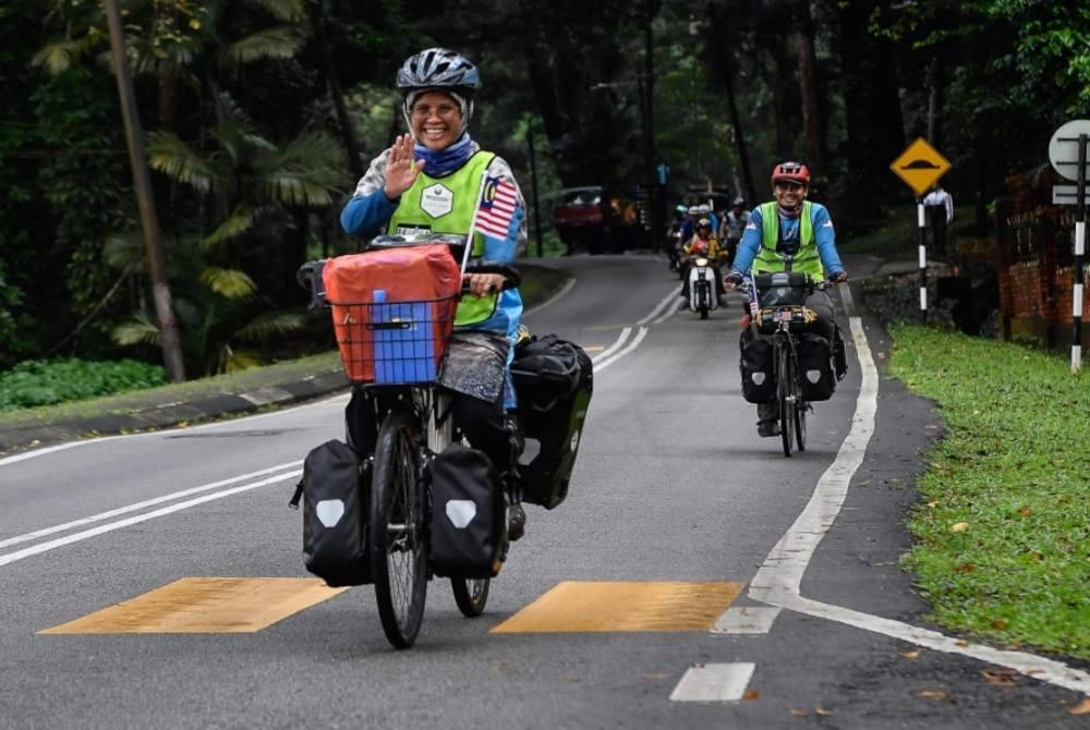 
Noradilah dan suaminya Ahmad (kanan) memulakan kayuhan di Masjid Jamek Institut Penyelidikan Perhutanan Malaysia (FRIM), pada Khamis. - Foto Bernama