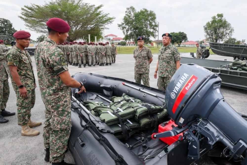 Aizuddin (kanan) meninjau aset yang digunakan untuk membantu mangsa banjir semasa melawat gerak kerja anggota yang terlibat dalam Op Murni di Batalion Kelapan Belas Rejimen Askar Melayu Diraja (Para), Kem Seri Pantai, Seberang Takir, hari ini. - Foto Bernama