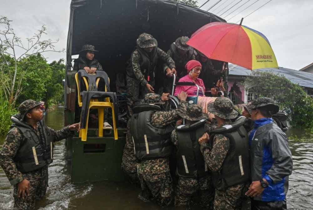 Anggota tentera melakukan operasi memindahkan mangsa banjir yang terlantar sakit akibat strok di Kampung Gong Baru pada Isnin lepas. - Foto Bernama