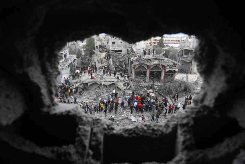 Orang ramai menjalankan kerja menyelamat di antara runtuhan bangunan yang musnah dalam serangan udara Israel di bandar Rafah, selatan Semenanjung Gaza. - Foto Xinhua