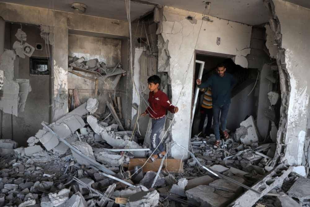 
Orang ramai memeriksa sebuah rumah yang rosak dalam serangan udara Israel di bandar Khan Younis, selatan Genting Gaza. - Foto Xinhua