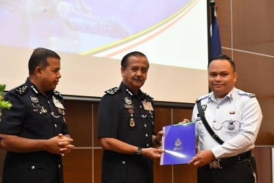 Razarudin (tengah) menyampaikan sijil penghargaan kepada anggota JSPT di Bukit Aman.