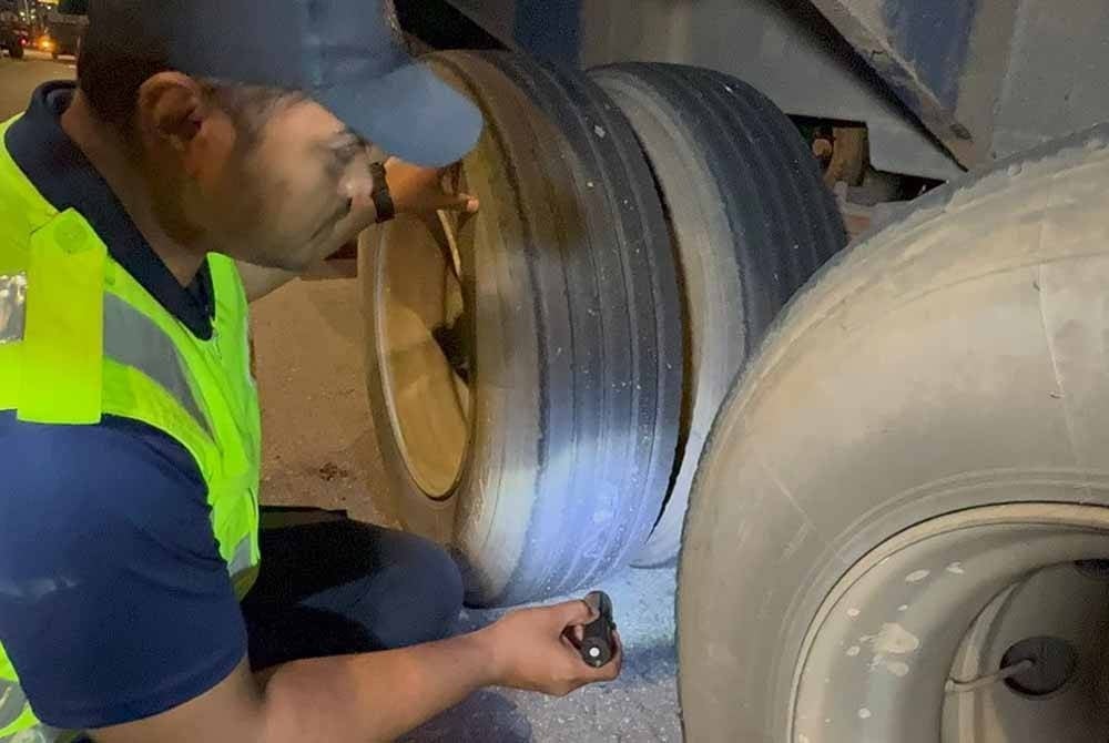Pegawai JPJ memeriksa tayar salah sebuah lori yang ditahan dalam Ops Khas Teknikal di Plaza Tol Juru, pada Khamis malam.