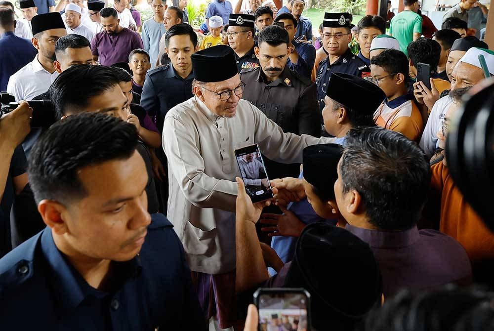 Anwar beramah mesra bersama para jemaah semasa hadir menunaikan Solat Jumaat di Surau Al-Furqan, Presint 11, Putrajaya hari ini. - Foto Bernama