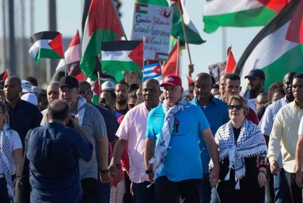 Díaz-Canel (tengah) turut diiringi isterinya,Lis Cuesta ketika menyertai perarakan pro-Palestin di Havana pada Khamis. - Foto: Agensi