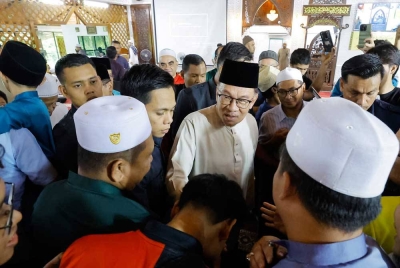 Anwar bersalaman bersama para jemaah semasa hadir menunaikan Solat Jumaat di Surau Al-Furqan, Presint 11, Putrajaya hari ini. - Foto Bernama