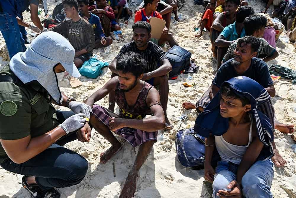 Pihak berkuasa Indonesia menanda setiap pelarian dengan gelang khas sebaik mereka tiba di pantai pulau Sabang, Aceh.