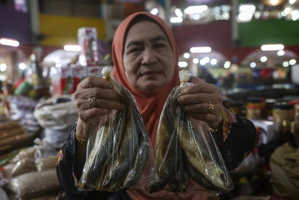 Rahmah menunjukkan 'Ikan budu' yang dijualnya di Pasar Siti Khadijah. - Foto Bernama