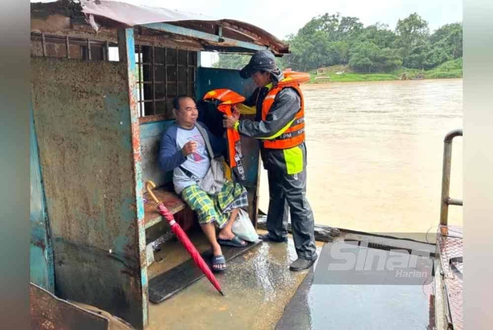 
Rosdi (kiri) dibantu Wan Azhar (kanan) memakai jaket keselamatan.