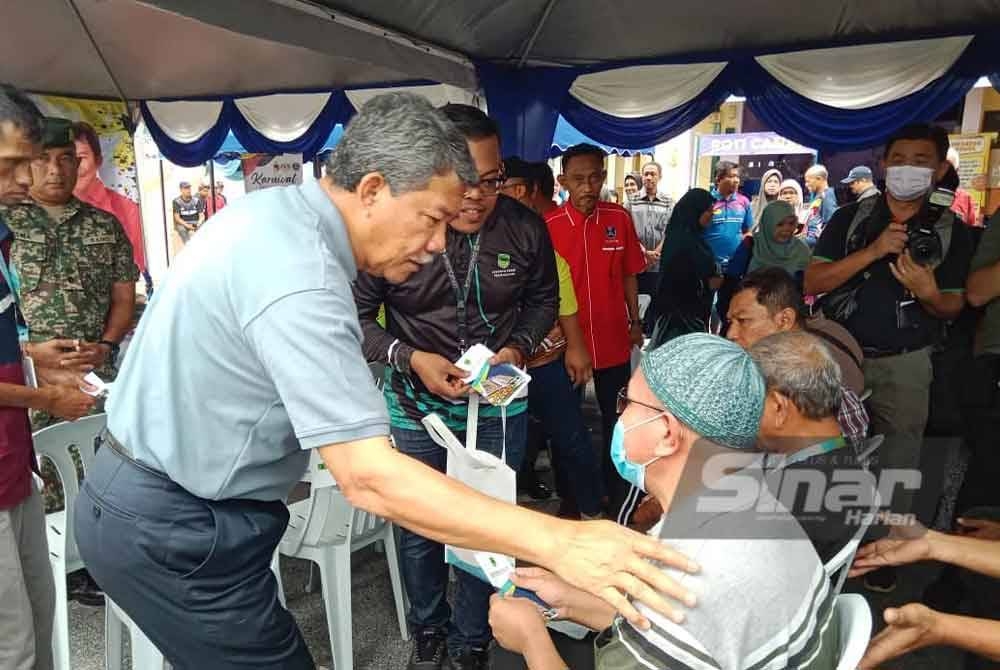 Mohamad (kiri) ketika menyampaikan sumbangan kepada asnaf.
