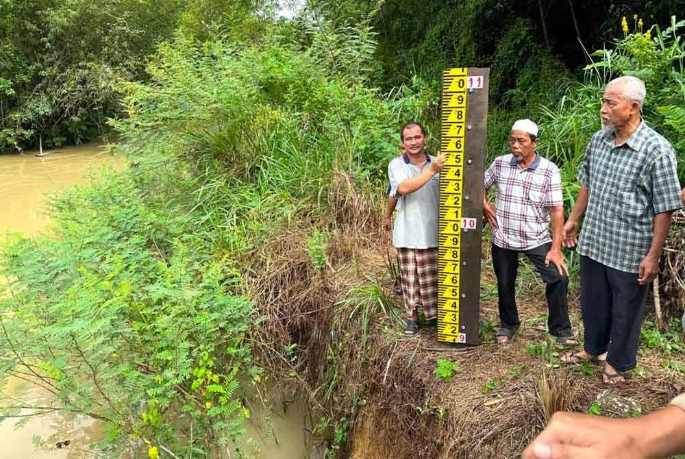 Penduduk menunjukkan aras air sungai di kawasan Kampung Sri Kulim jika banjir.