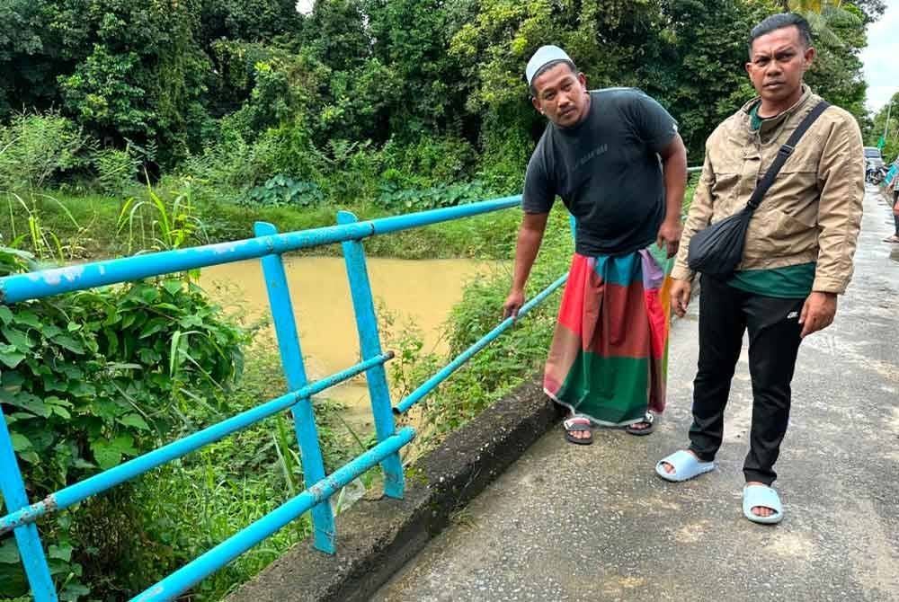Mohd Shukri (kiri) dan Fadli Shah (kanan) menunjukkan besi jambatan yang patah.