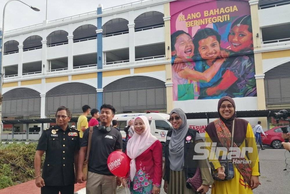Noraini (tengah) bergambar bersama MieyAli (dua dari kiri) dan Nurhayati (dua dari kanan) dengan latar belakang mural Klang Bahagia Berintegriti.